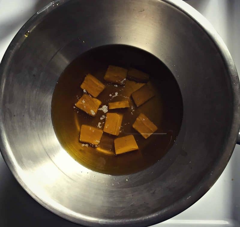 melting beeswax into infused oil with a double boiler