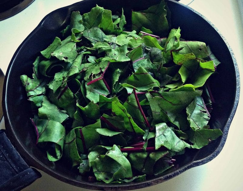 fresh chopped beet greens in a cast iron pan