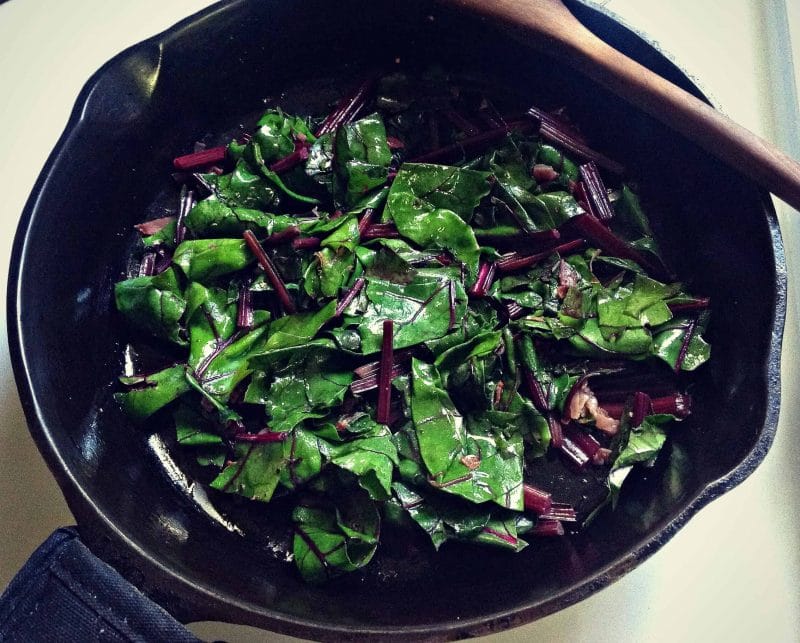 sauteed beet greens in a cast iron skillet