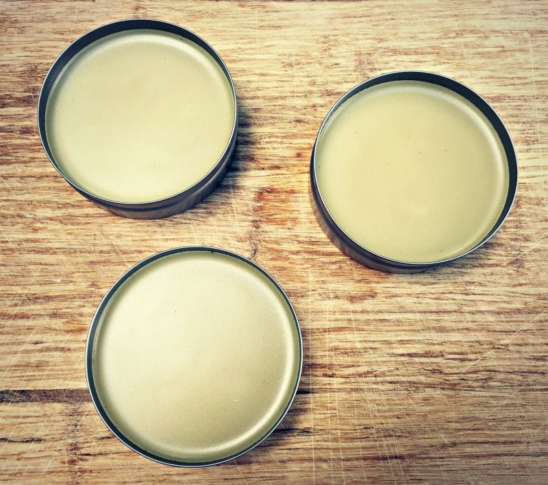 three tins of solidified salve