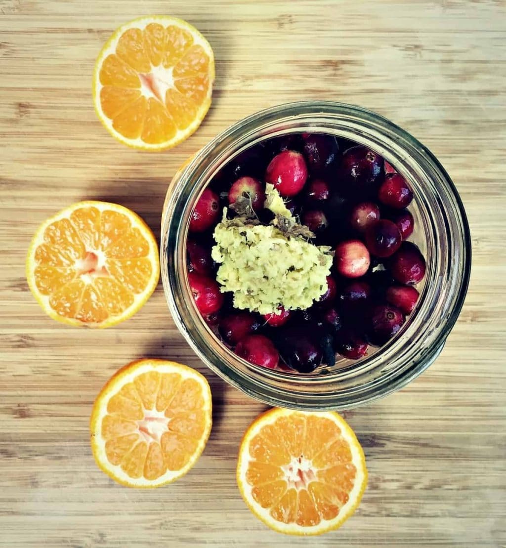 adding orange and ginger to cranberries