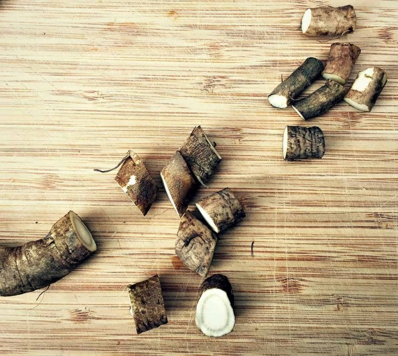 slicing burdock root on a cutting board