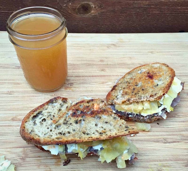 reuben sandwich with a glass of hard cider