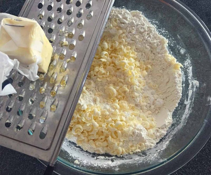 grate frozen butter into the bowl