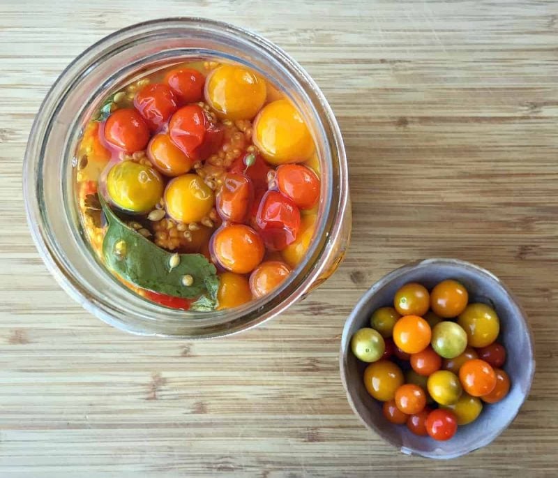 fermented cherry tomatoes in a jar and bowl