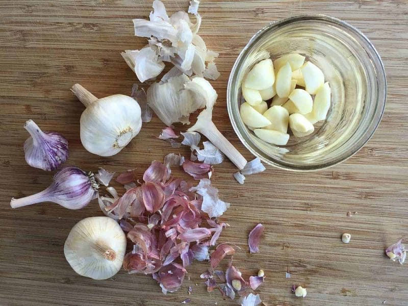 peeling whole garlic cloves in a jar