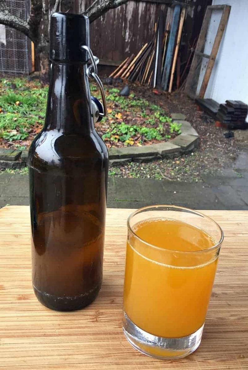 a glass of turmeric soda and a flip top bottle