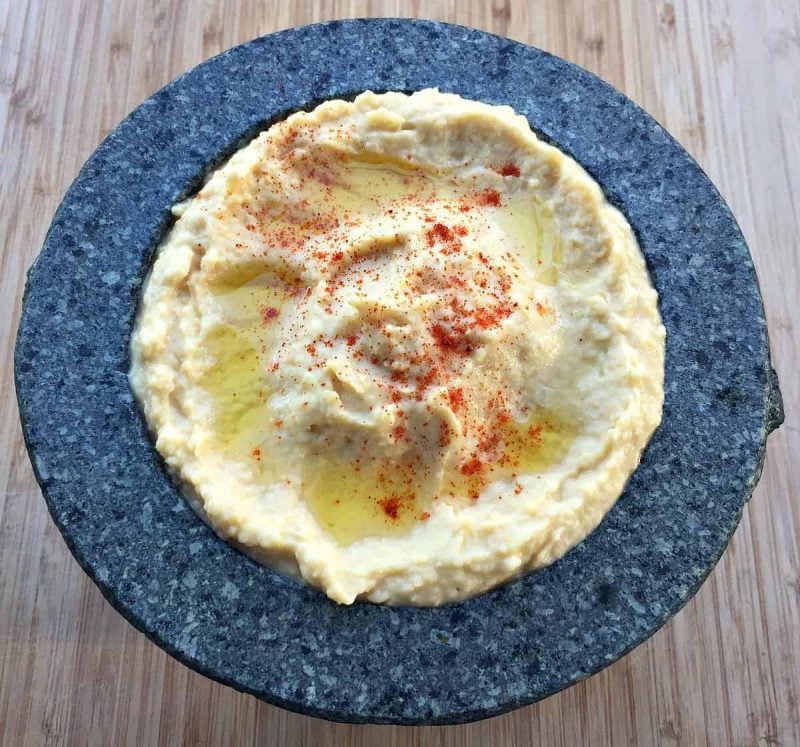 a stone mortar filled with homemade hummus