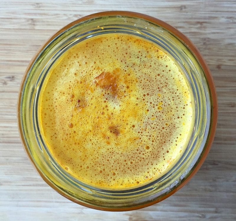 top view of turmeric soda bubbles in a jar