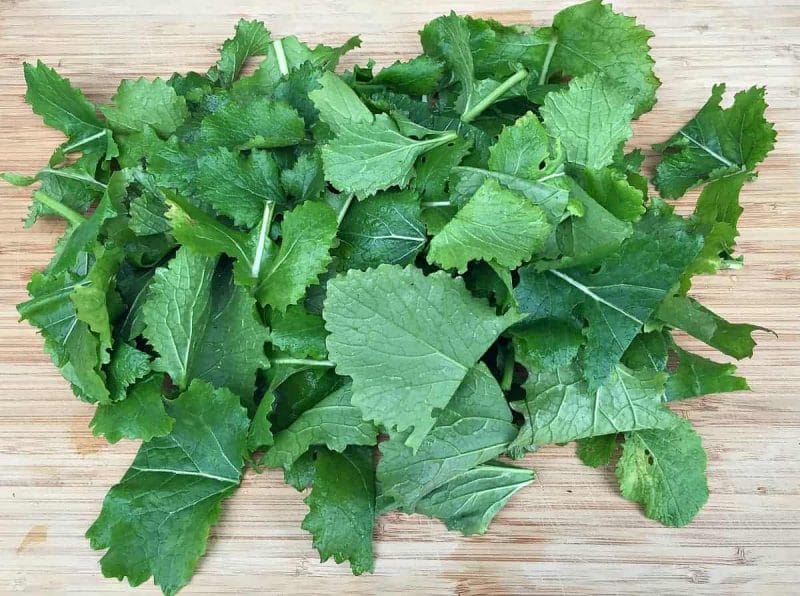 chopped turnip greens on a wooden cutting board