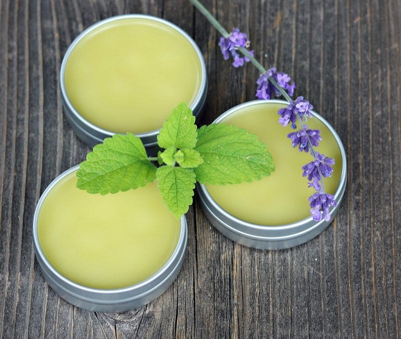 three tins of no bug balm on a wooden board