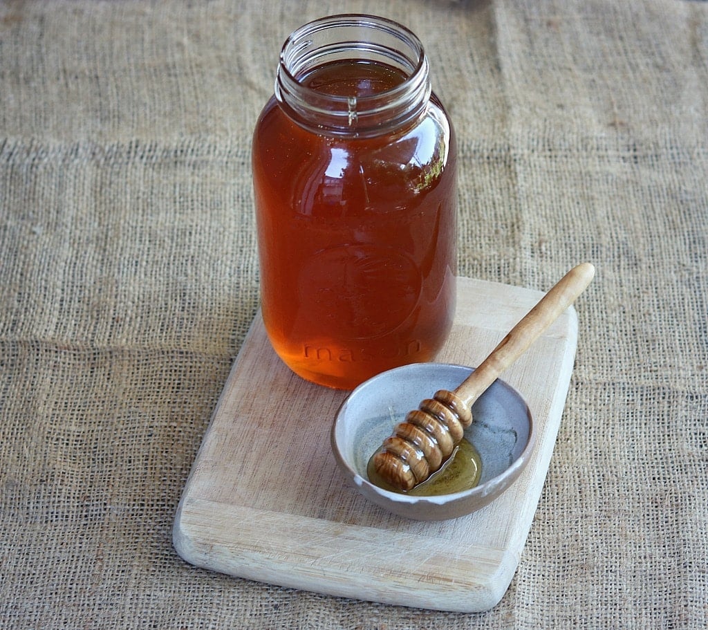 a jar of honey with a honey dipper