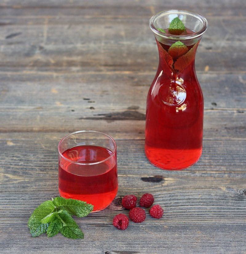 a carafe and a glass of ruby red raspberry mint infused wine