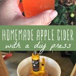 A glass of homemade apple cider and a DIY apple cider press.