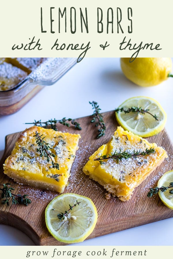 lemon bars with a sprig of thyme garnish on a wooden cutting board