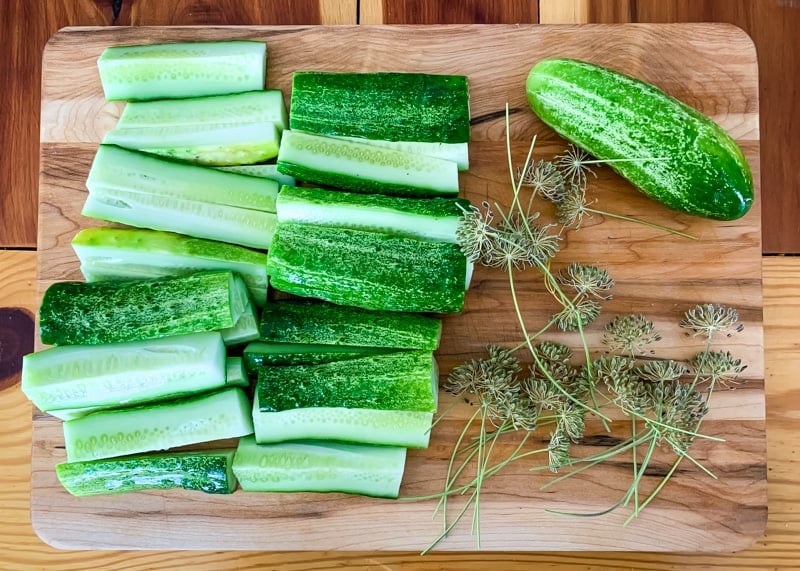 pickling cucumber quarters on a cutting board