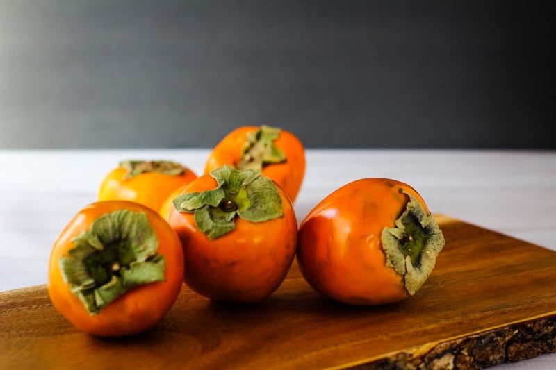 hachiya persimmons on a wooden board