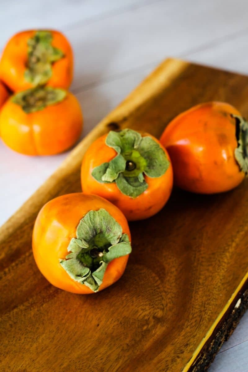 persimmons on a wooden board