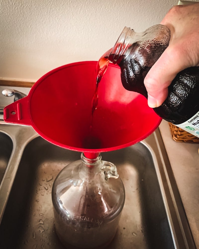 pouring pomegrante juice into the jug