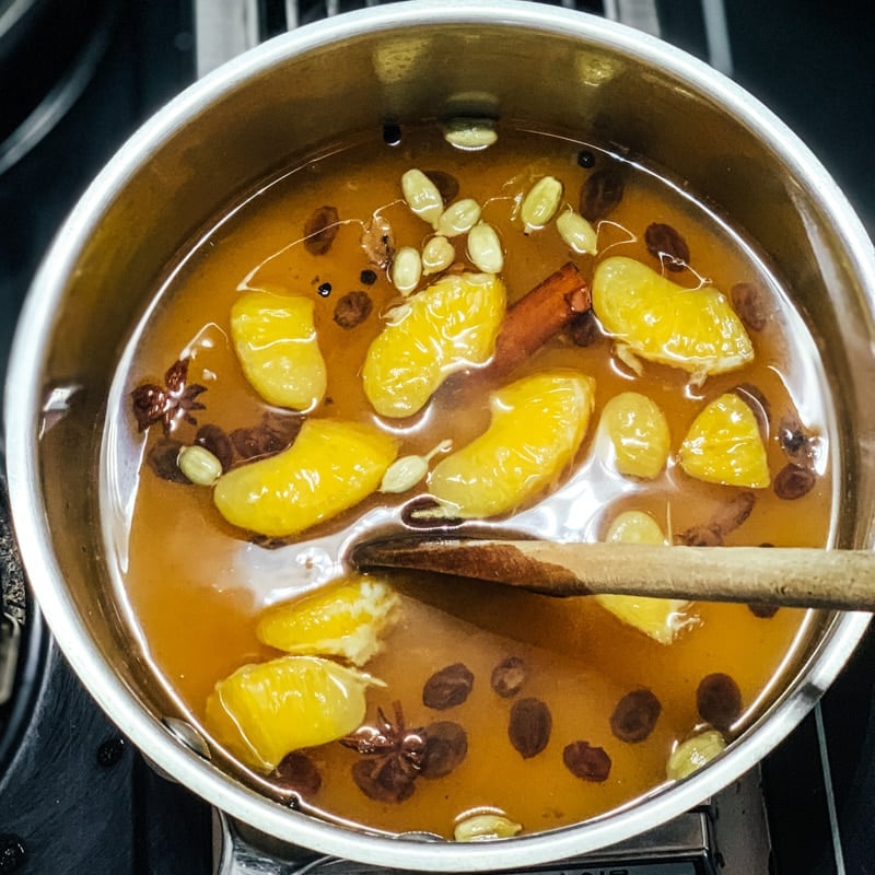 a pot with oranges and spices