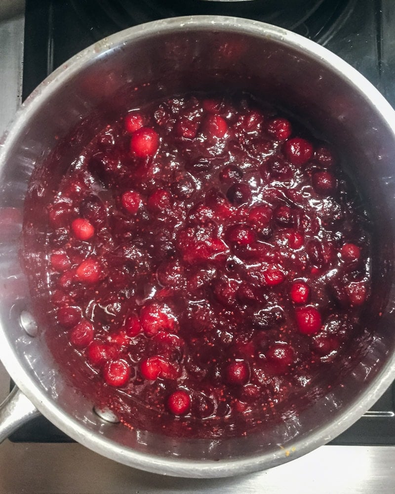 spiced cranberry sauce cooking in a pot