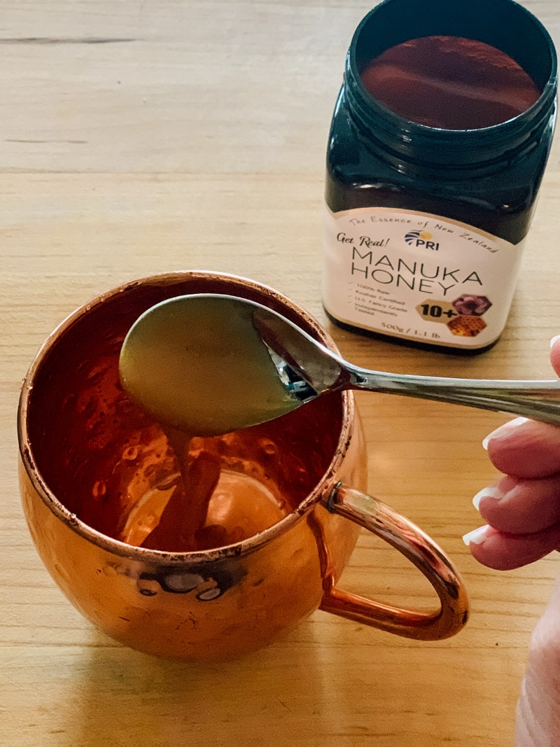 putting a spoonful of manuka honey in a mug