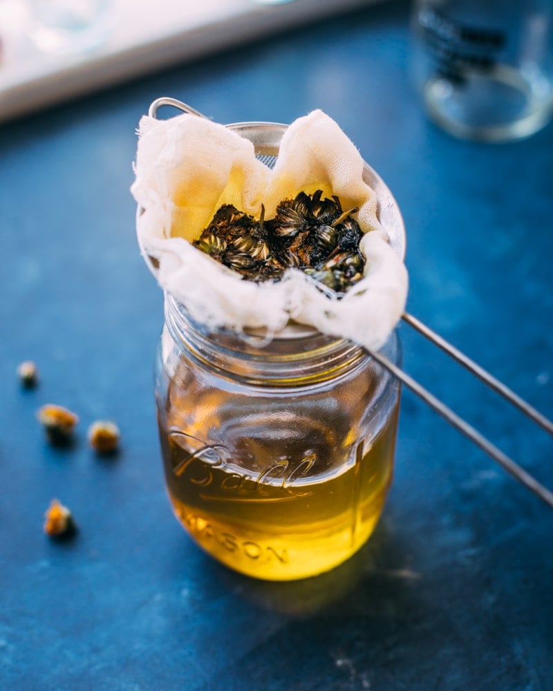 straining out the dandelion flowers