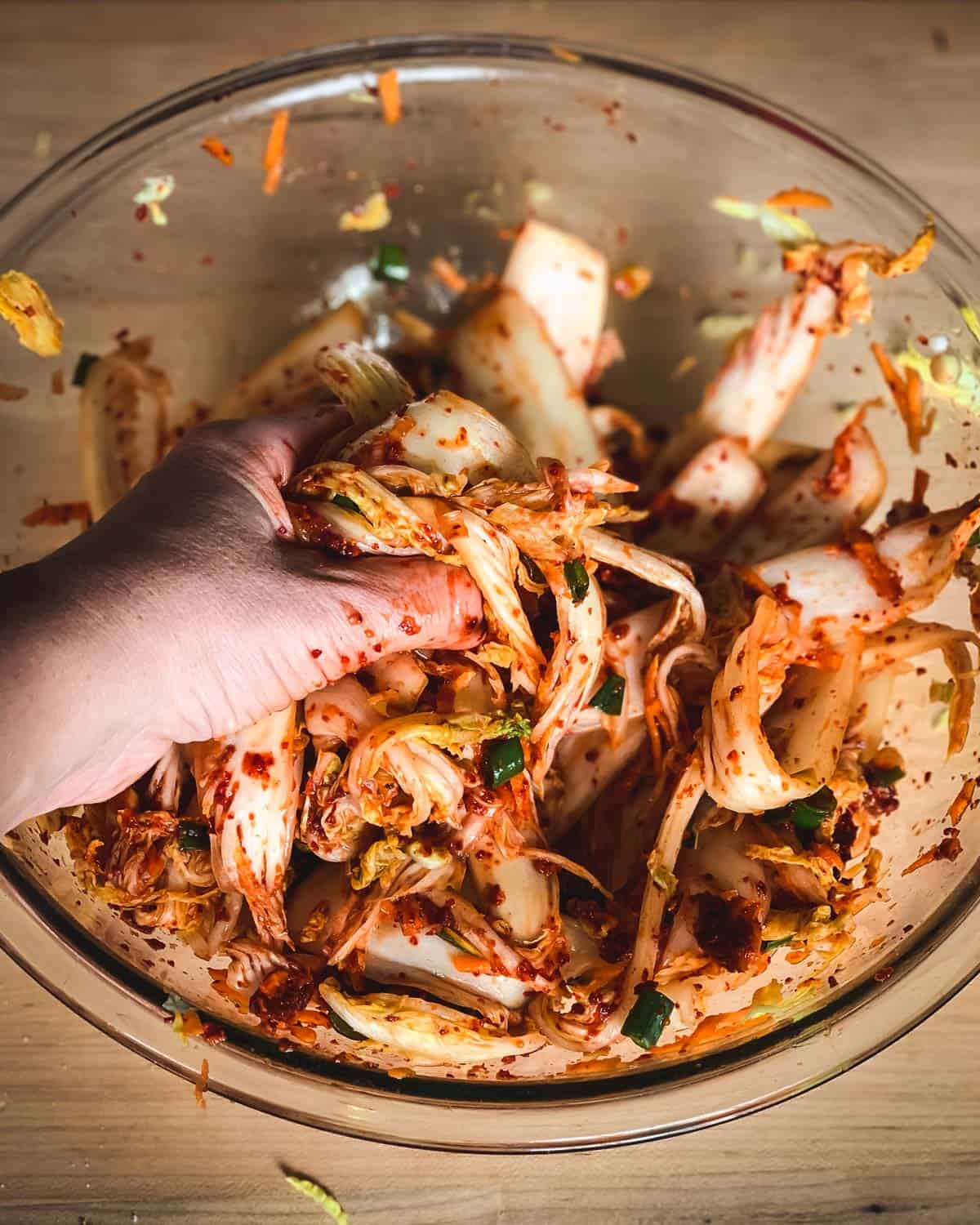 a hand massaging the spices into the cabbage