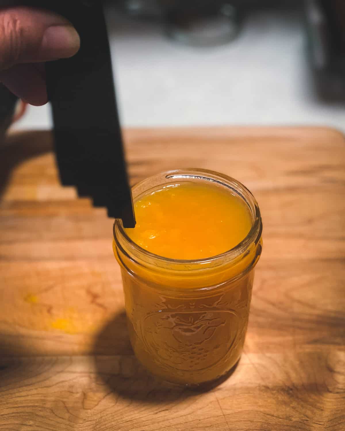 measuring the head space on the jar of peach jam