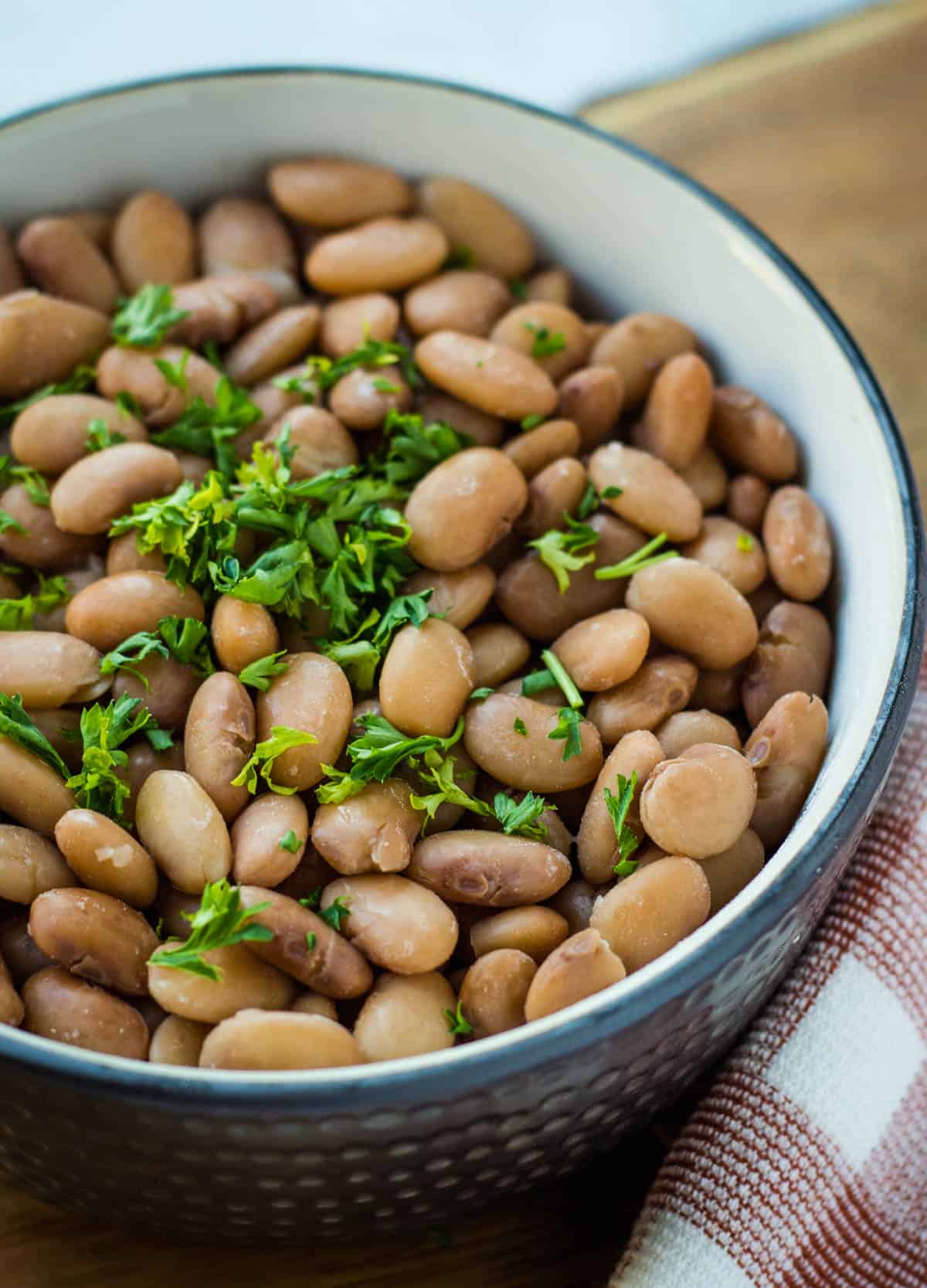 a bowl of cooked pinto beans with parsely for garnish