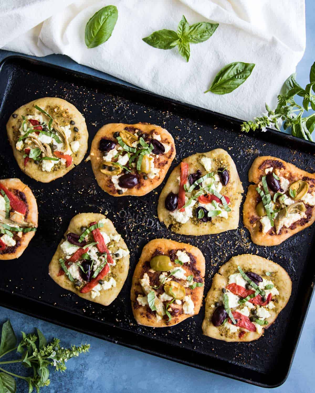 mini sourdough appetizer pizzas on a sheet pan