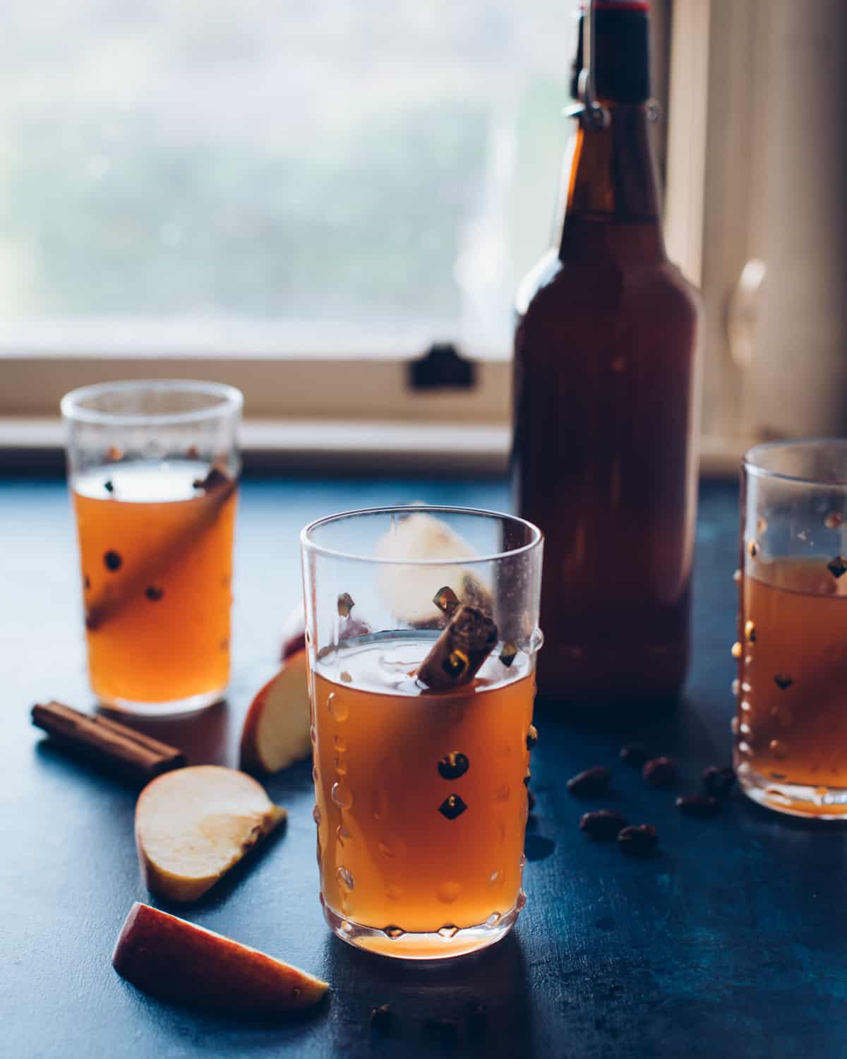 three glasses and a bottle of hard cider