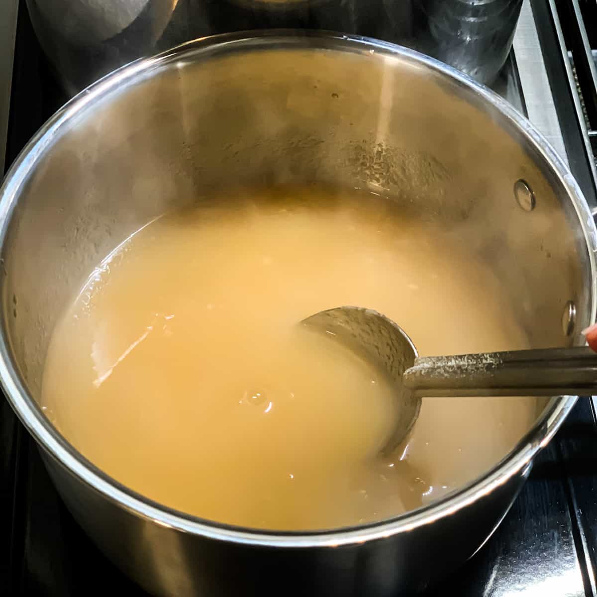 stirring the apple jelly mixture in a pot