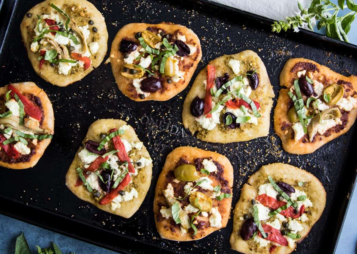 Sourdough mini pizzas on a baking sheet. 