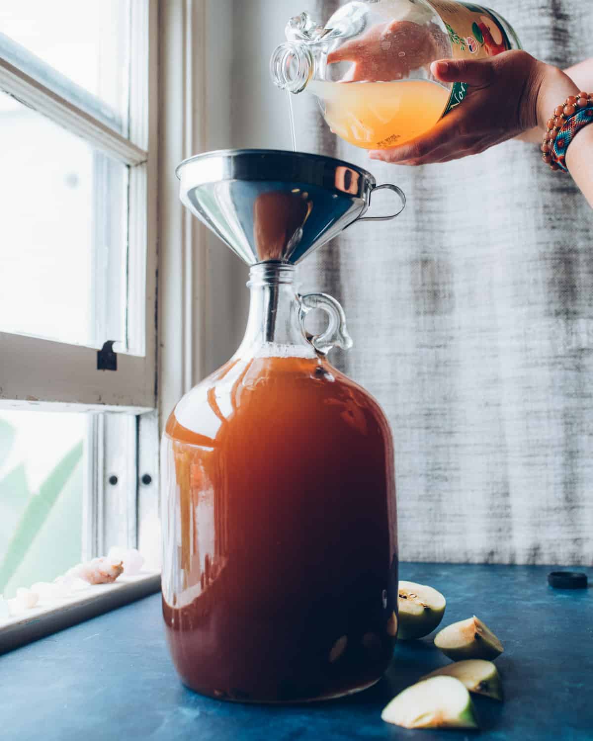 pouring the rest of the apple juice into the jug