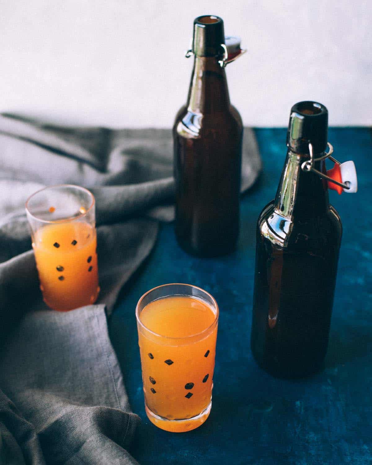 two glasses and two bottles of hard cider