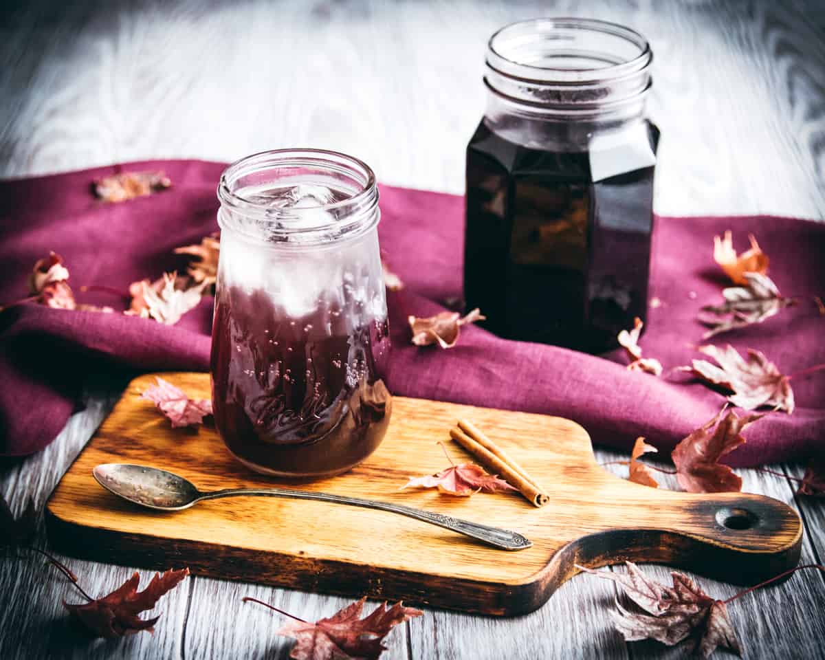 elderberry cocktail on a board with a spoon