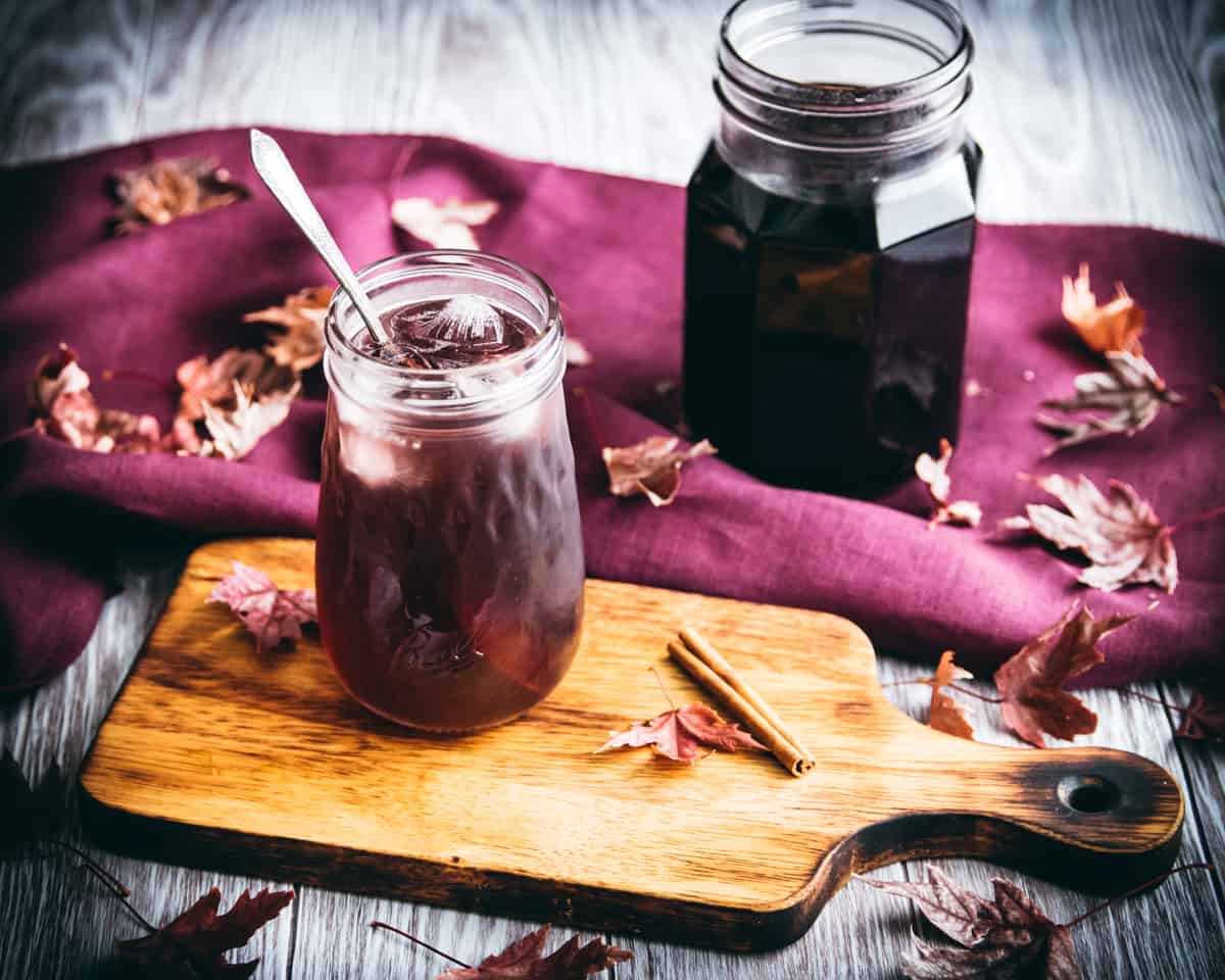 elderberry cocktail in a ball flute jar with a spoon