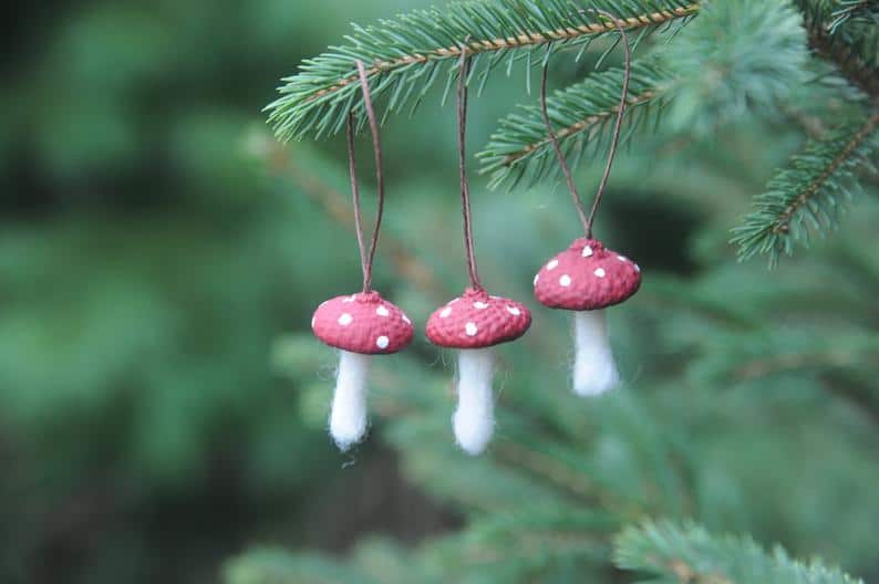 3 mushroom ornaments hanging on a tree