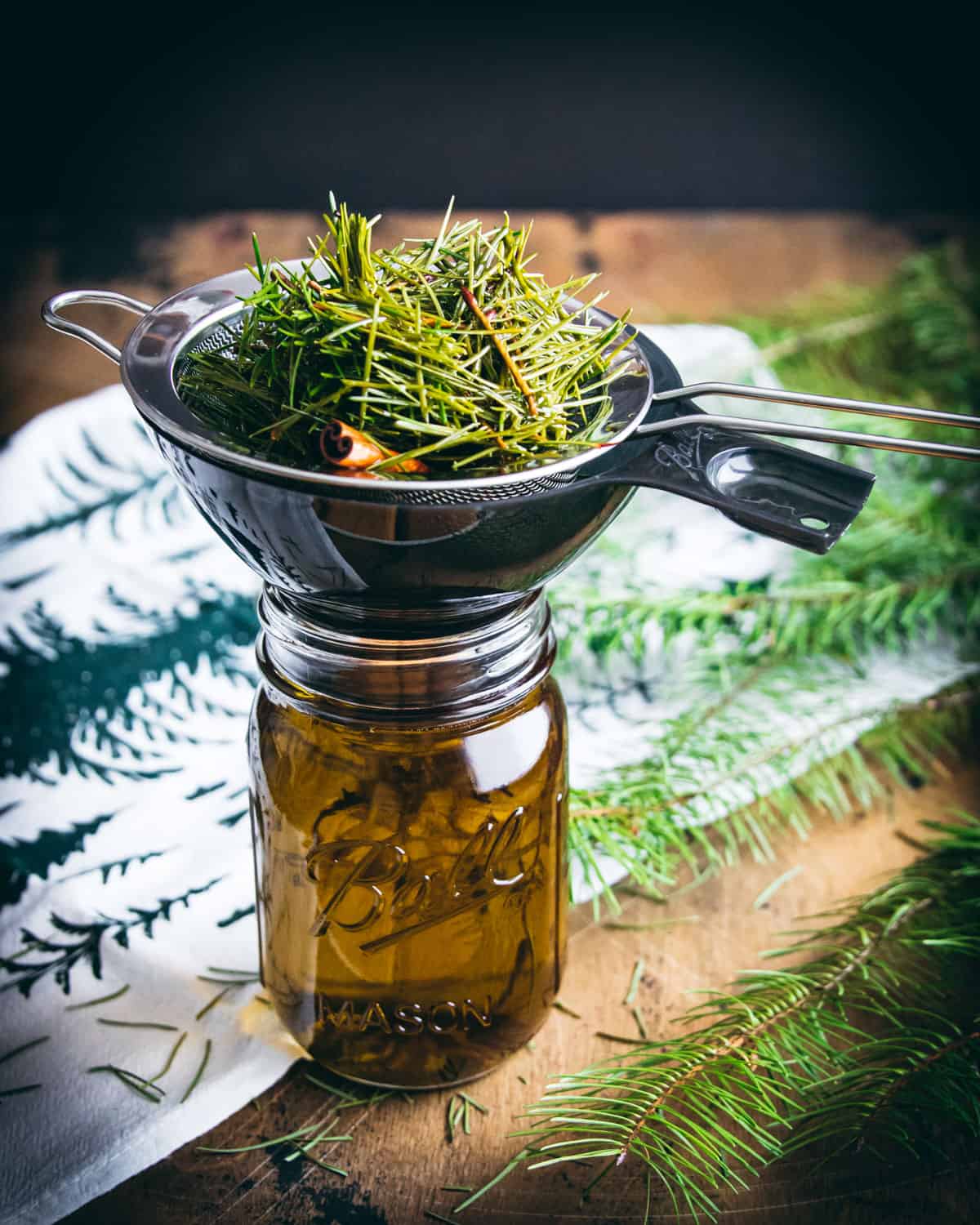 straining out the conifer infused oil with a fine mesh sieve