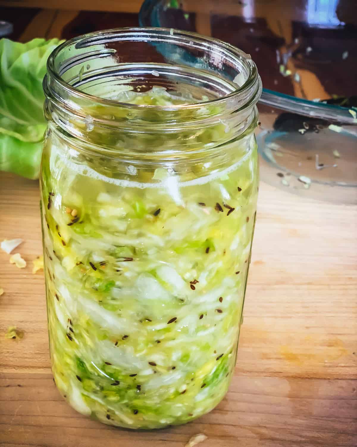 a quart jar of cabbage with liquid on top