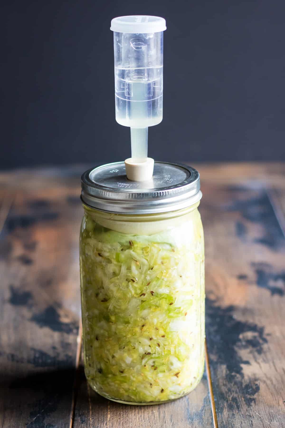 a jar of sauerkraut with an airlock