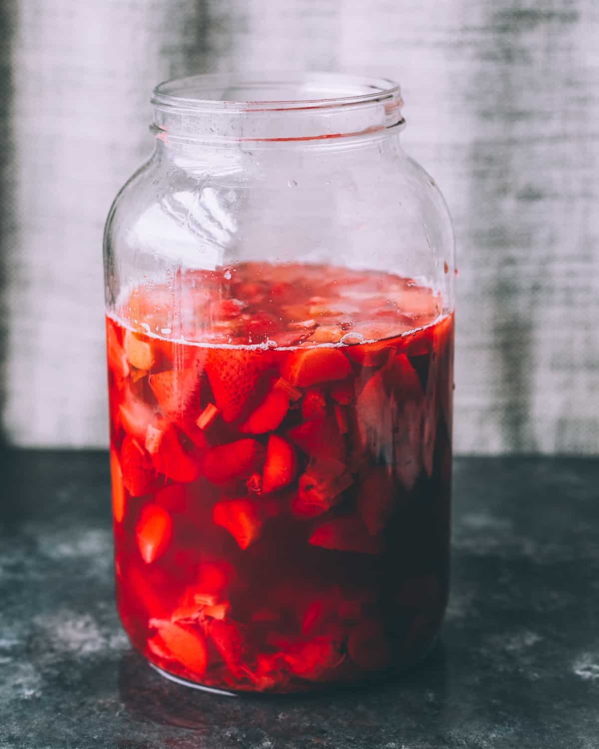 strawberries and rhubarb in a gallon jar to ferment