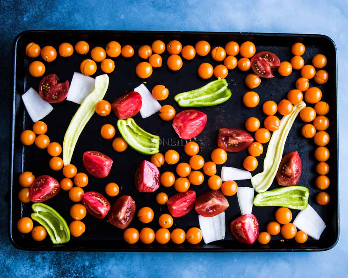 a sheet pan with tomatoes and peppers