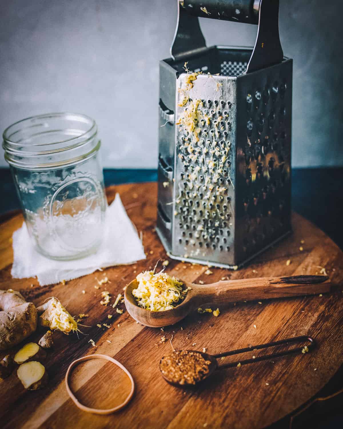 a cheese grater and a wooden spoon of grated ginger