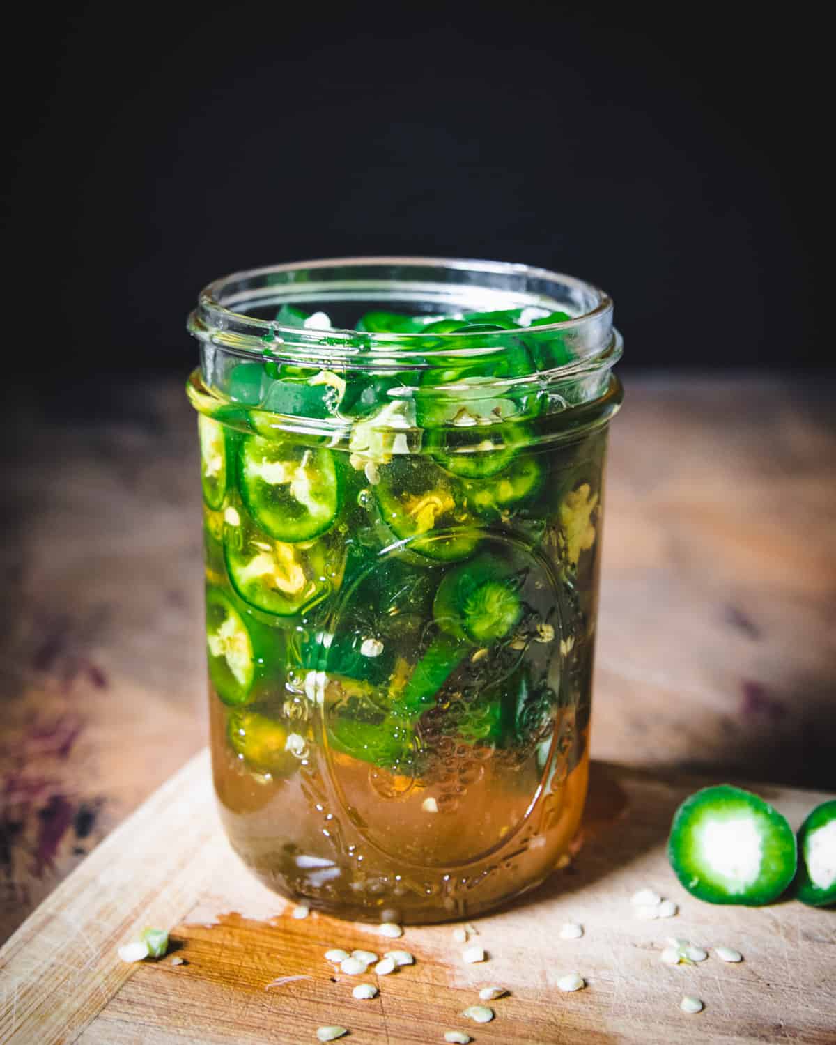 Jar filled with sliced jalapeños and honey.