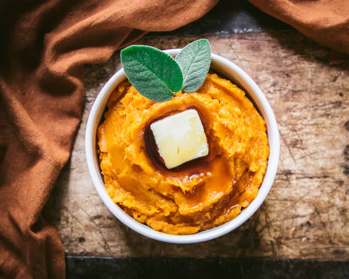 a bowl of mashed butternut squash on a wooden table