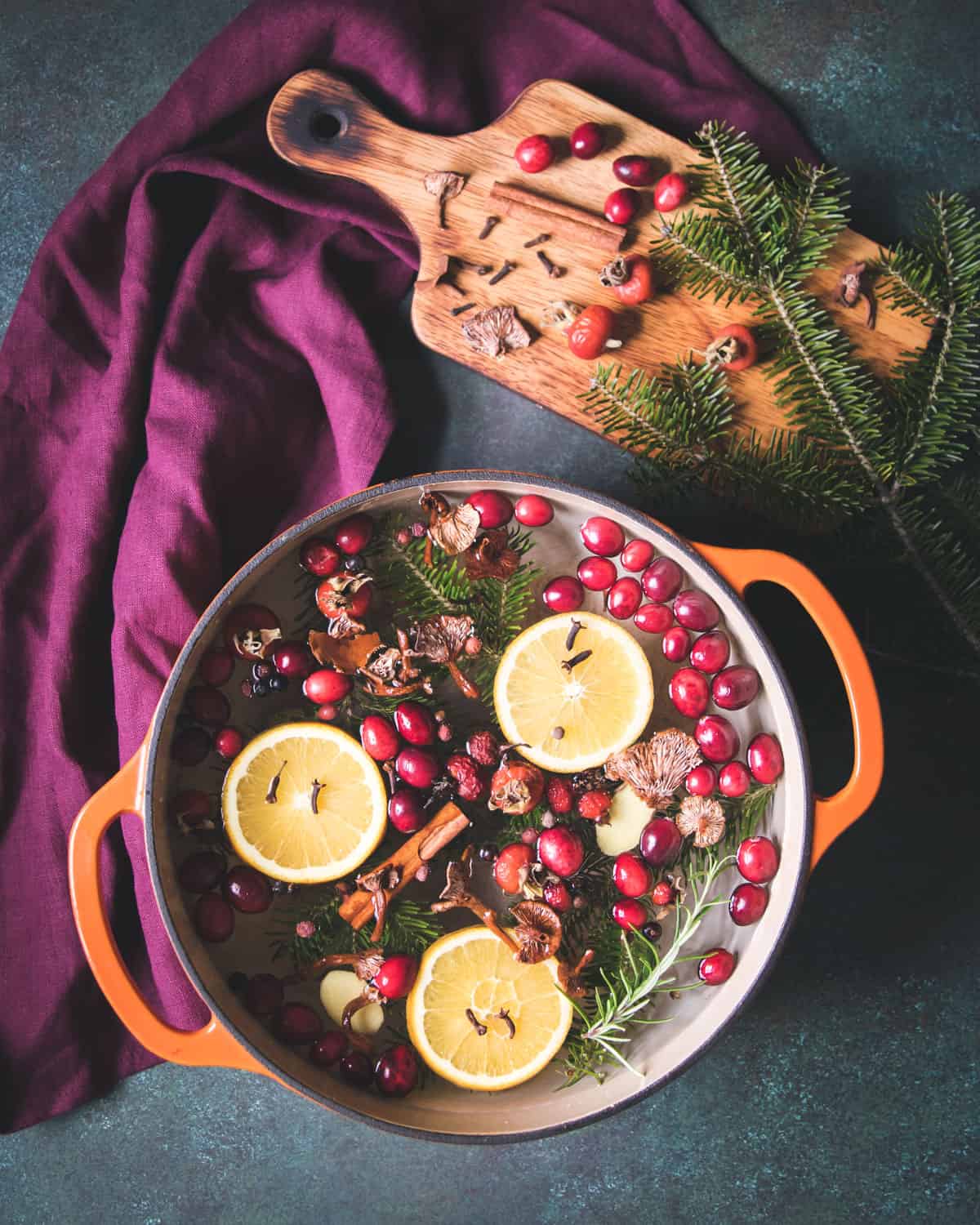 a simmer pot filled with foraged ingredients, spices, and orange slices