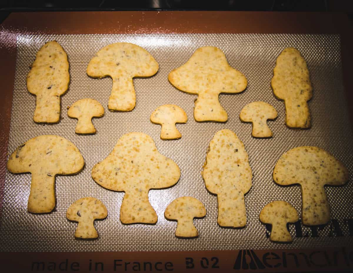 baked mushroom cookies on a sheet pan with a silicone mat