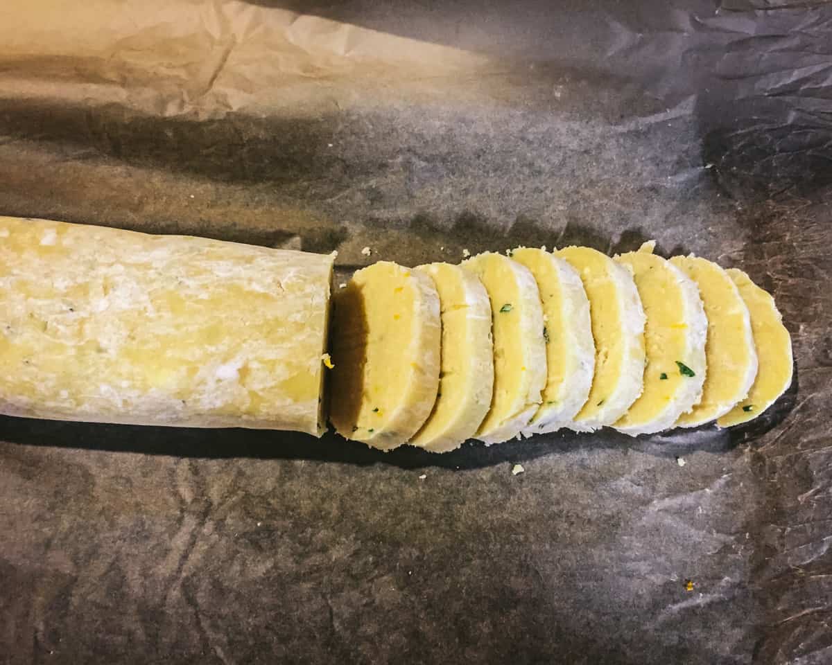 slicing the lemon rosemary shortbread cookie dough log